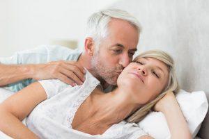 man over 50 without Erectile dysfunction problems in bed kissing woman on cheek